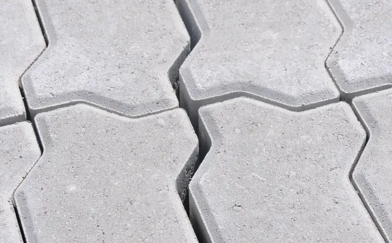 Close-up top-down view of gray interlocking zigzag-shaped concrete pavers fitted tightly together